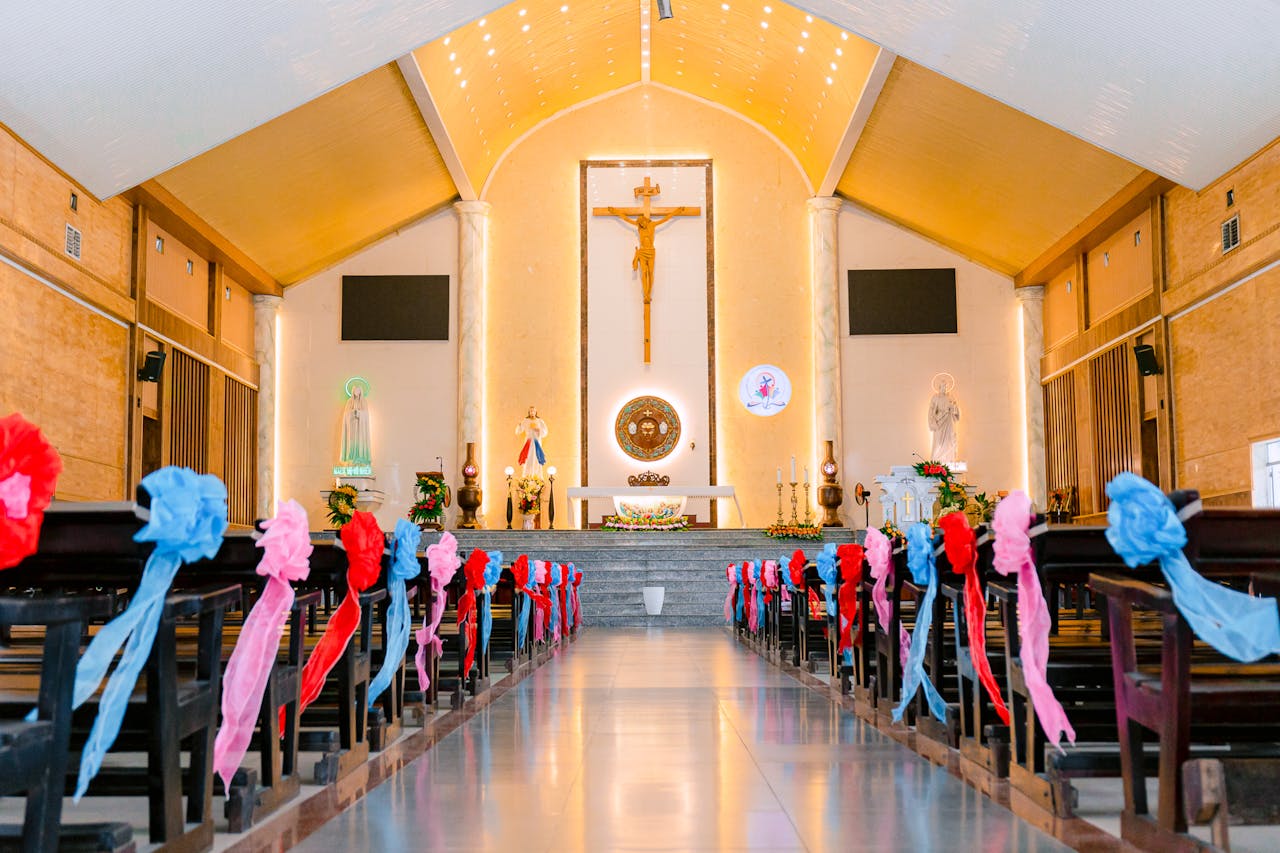 Beautifully decorated church aisle with altarpiece, ribbons, and religious statues. Perfect for celebrations.